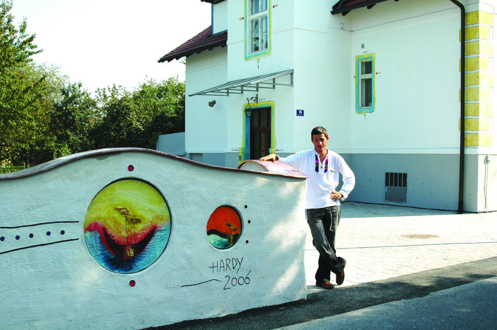 Künstlerische Außengestaltung mit Wandkunst und Glas-Elementen an einer Hausmauer – individuelles Unikat von Hardy