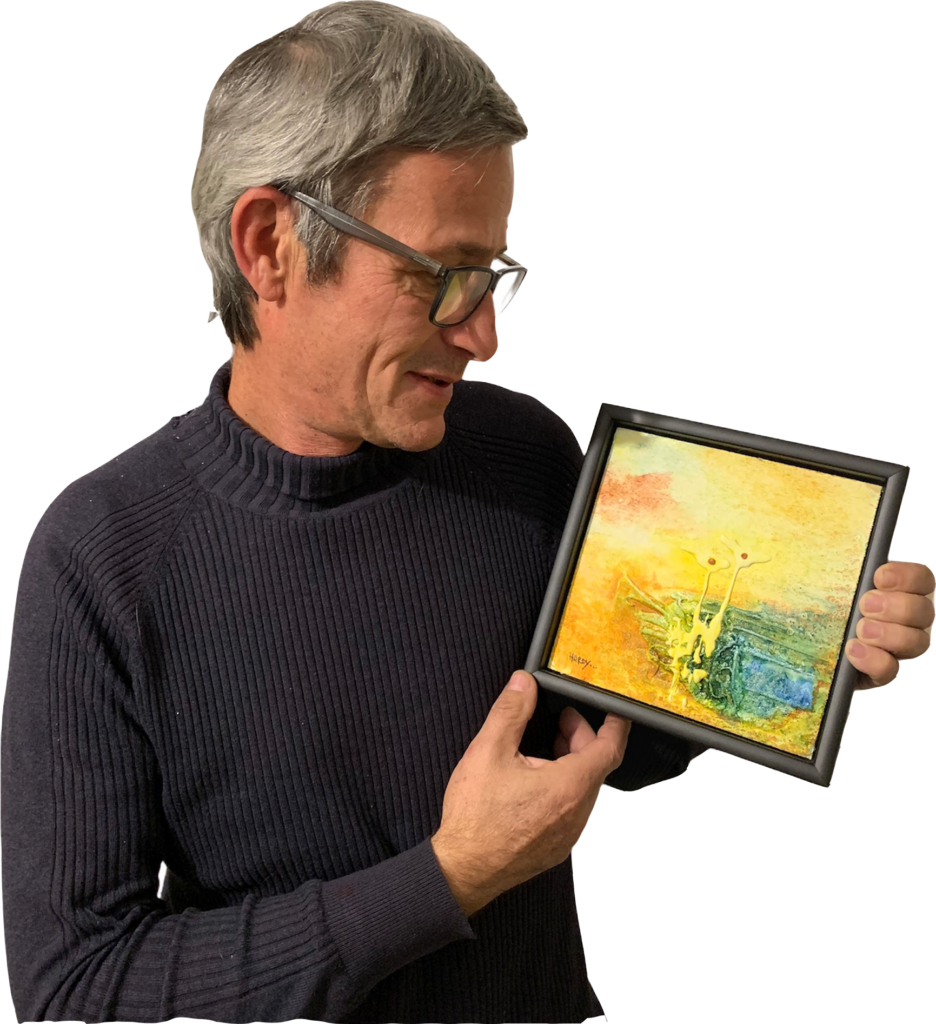 Hardy Brandner, freischaffender Kärntner Künstler, hält ein abstraktes Gemälde in seinem Atelier in Kärnten